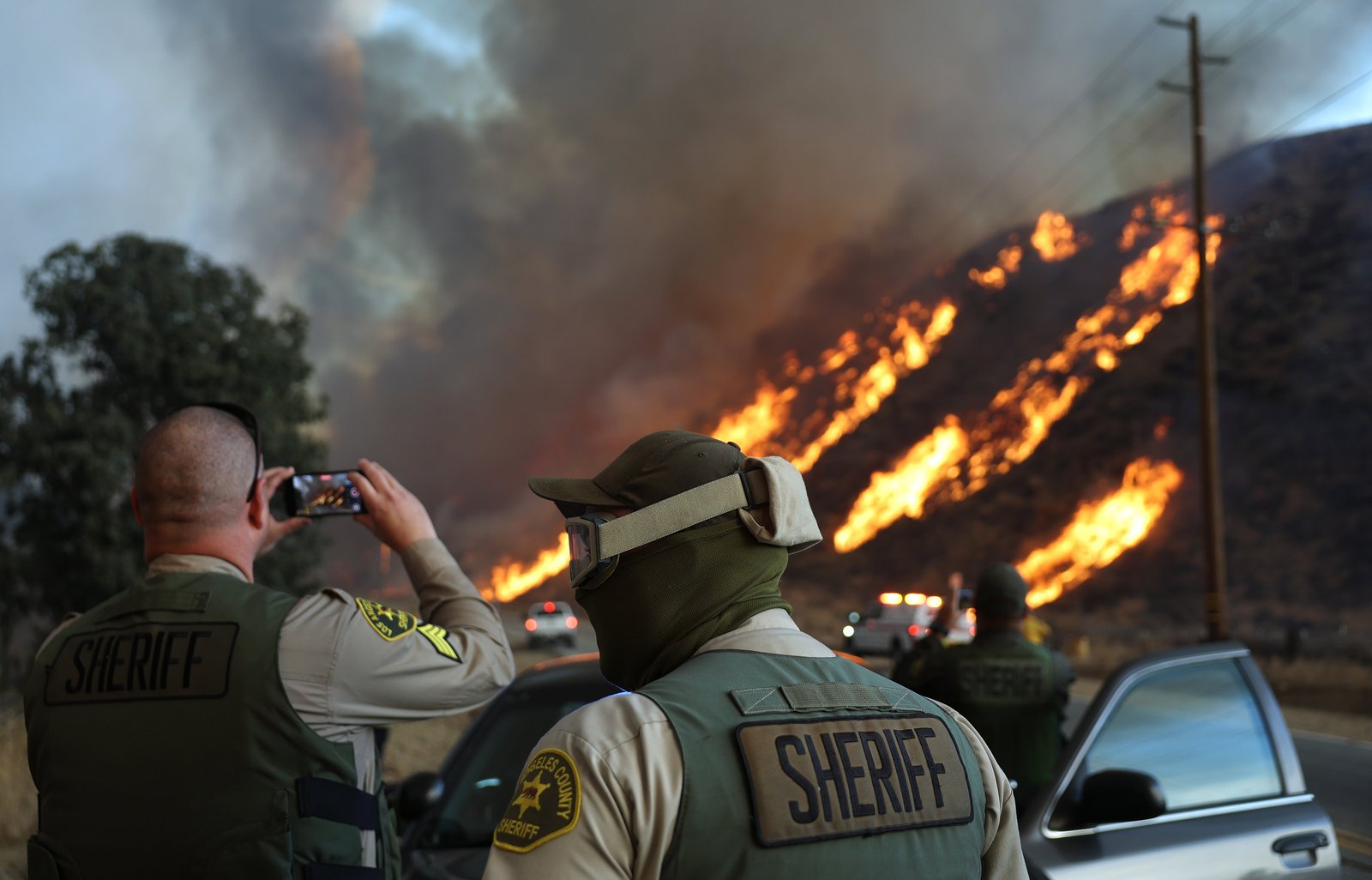 Los Angeles County Sheriff's deputies stand watch as the Hughes Fire burns near Castaic, California, north of Los Angeles.