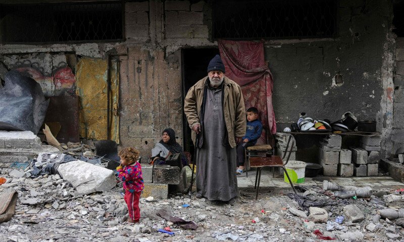 In Pictures: Palestinians pose in front of their destroyed homes in Gaza - World