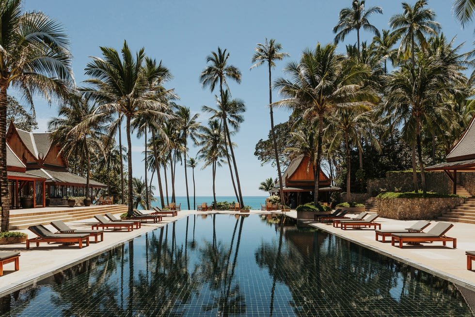 Tropical resort with pool and palm trees overlooking the ocean.