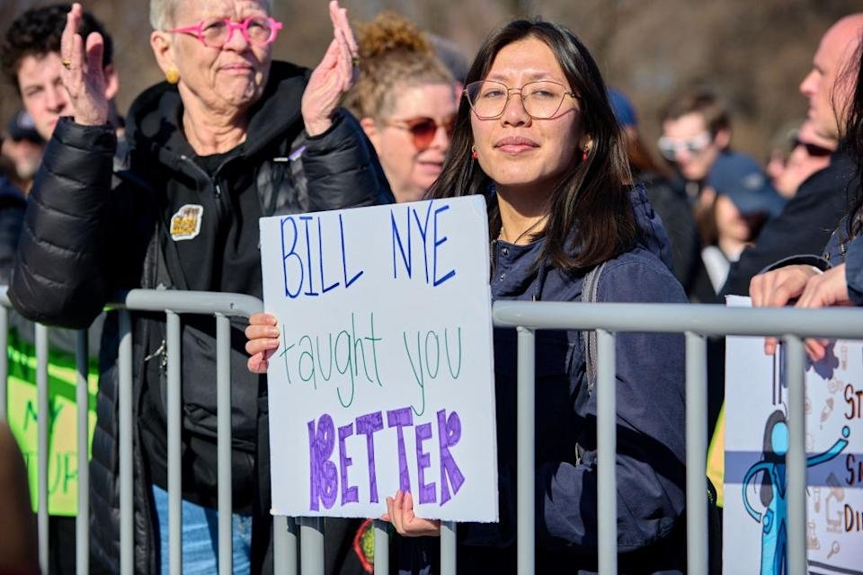 A person has a sign that says & quot; Billi taught you better & quot; Are playing other claps in a protest