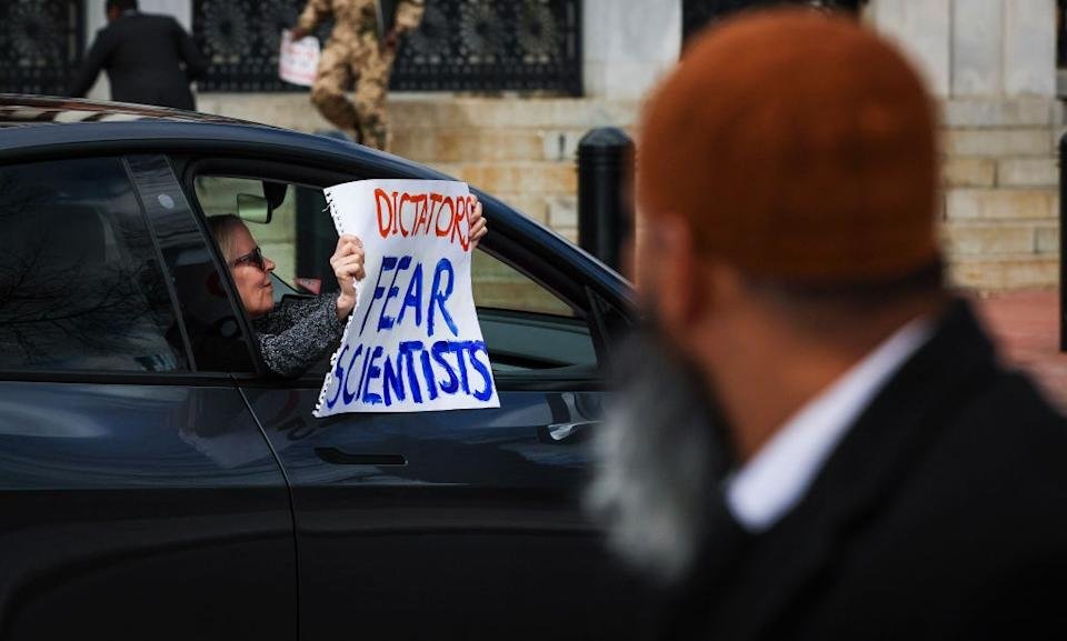 The person in the car has to read the protest mark & ​​quot; Dictators are afraid of scientists, & quot; To observe with a passer -by in the forecast