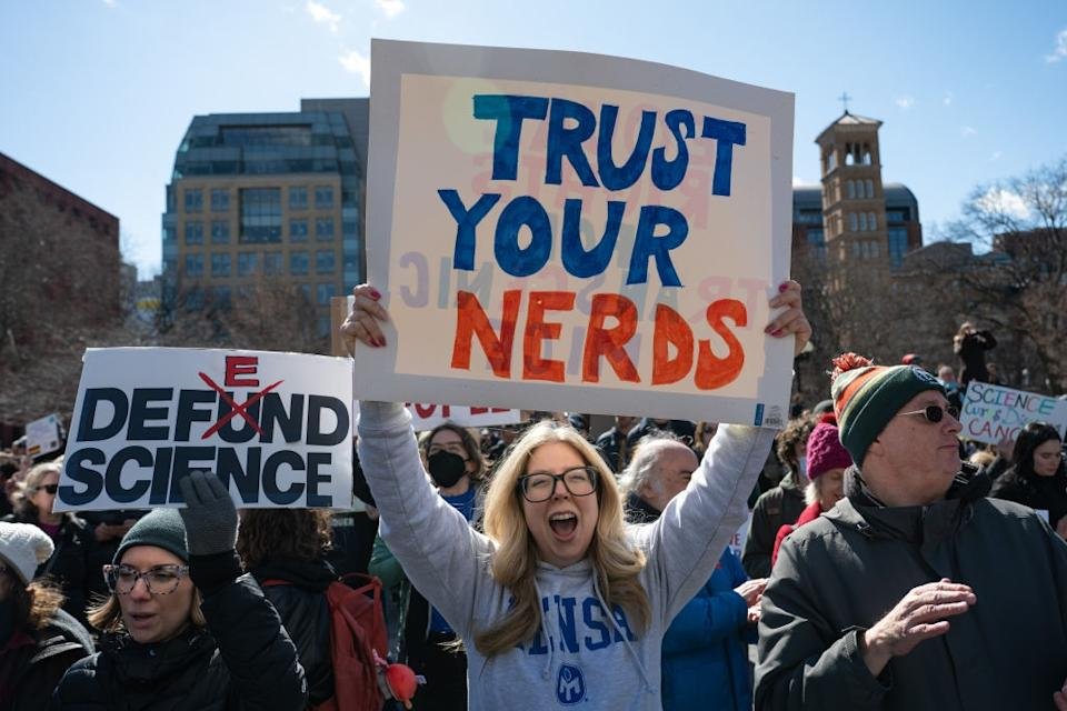 Reading a sign of a person involved in the crowd & quot; Trust on your nerve & quot; Other signs support science during a rally. People are dressed for cold weather