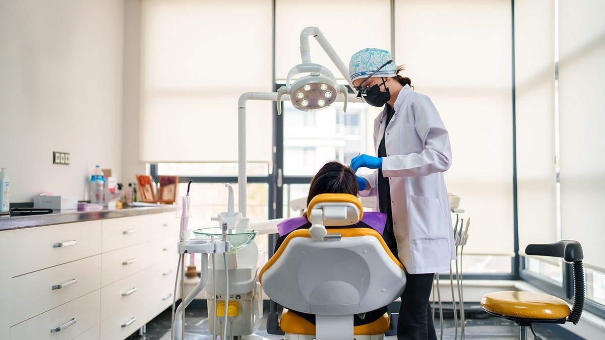 Dental doctors to work on the patient's mouth in a wide shot of the dentist's office