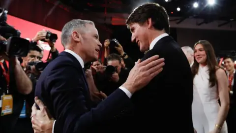 Reuters Mark Carney and Justin Trudeau hugs when a crowd of photographers pulls photos and the daughter of Trudeau, who introduced her father in the Liberal Party event, Watch On. 