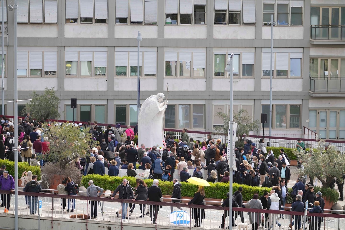 People wait before Pope Francis will appear at a window of the Agostino Gemelli Polyclinic in Rome, Sunday, March 23, 2025, where he has been treated for bronchitis and bilateral pneumonia since Feb. 14.