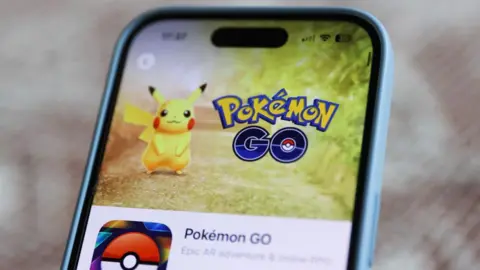 Getty Images Pokémon Go Logo as well as puck on the phone screen.